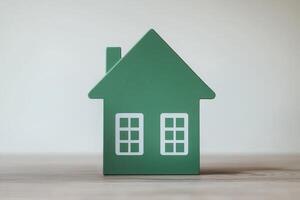 Sustainable energy efficiency concept. Green house model with windows, set against a light background, symbolizing home, comfort, and security. photo