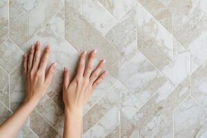 Home improvement with renovation trends concept. Hands touching a patterned marble surface, showcasing a modern design with geometric shapes and neutral colors. photo