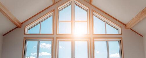 Home improvement with sustainable building concept. Room featuring large windows that allow sunlight to flood in, highlighting wooden beams and a clear sky outside. photo