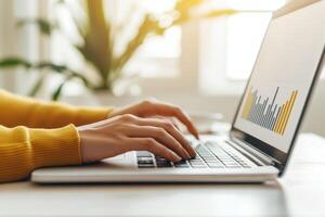 Business entrepreneurship with remote work concept. Person types on a laptop, analyzing data represented by colorful graphs on the screen in a bright, modern workspace. photo