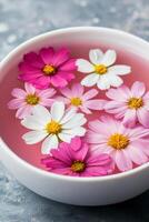Lifestyle wellness with mental health and self-care concept. Floating flowers in a bowl of pink water. photo
