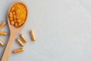 Health supplements and natural remedies concept. Wooden spoon with dietary supplements on a textured surface. photo