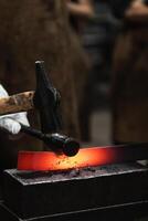 A blacksmith is working on a piece of metal photo