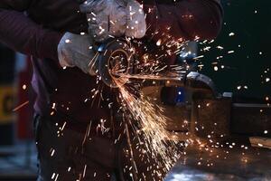 A man is grinding metal with sparks photo