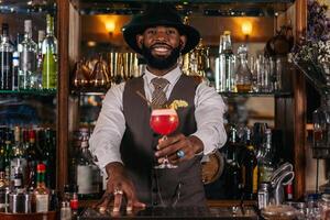 A bartender with a drink in front of him photo