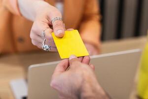 A person handing a yellow card to another person photo