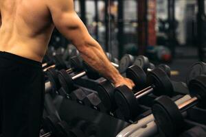 A man is standing in front of a gym with dumbbells photo