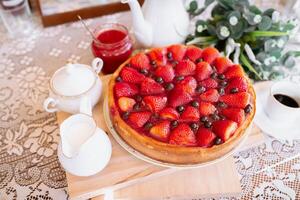from above a strawberries cake on table with coffee and milk photo