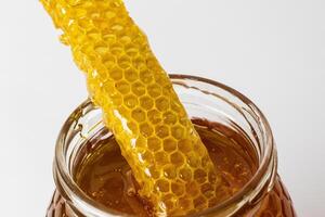 Honey with honeycomb in glass jar photo