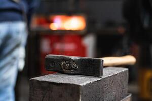 Hammer on workbench in blacksmith workshop photo