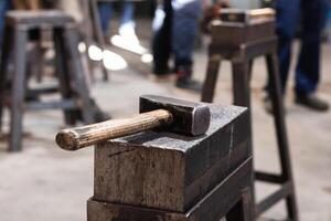 Hammer on workbench in blacksmith workshop photo