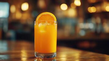 Glass of orange juice with a slice of orange on top photo