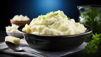 A bowl of mashed potatoes with a spoon and butter photo