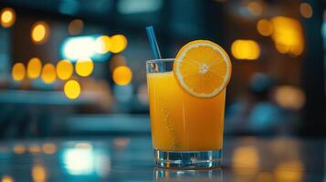 A glass of orange juice with a slice of lemon on the side. photo
