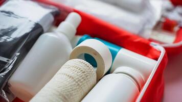 A bright red first aid kit, meticulously filled with various bandages, bottles, and a handy spray bottle, ensuring that you are prepared for any healthrelated emergencies that may arise photo