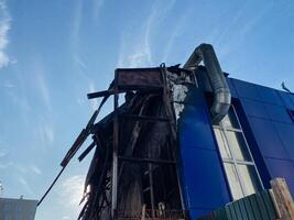 A large blue building, which features a prominent and noticeable pipe, is currently undergoing the process of demolition in order to clear the area for future developments and projects photo