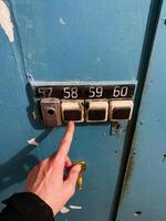 A person can be seen clearly and unmistakably pointing at the number 57, which is displayed prominently on a vibrant and bright blue door, effectively drawing attention to it for all to see photo