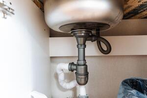A sink that features a drain pipe located underneath it, which is an essential plumbing fixture found in many homes and is often associated with cleanliness and functionality photo
