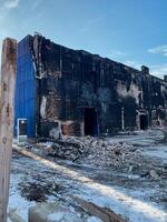 The devastating aftermath of a firedamaged commercial building is evident with its charred facade and surrounding rubble, illustrating the destruction left behind photo