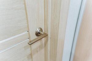 This closeup image showcases a stunning door handle on an elegant wooden door, highlighting its intricate design and exceptional craftsmanship, making it truly remarkable photo