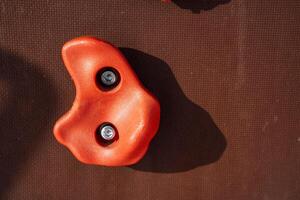 A vibrant array of red climbing holds is arranged on a robust wall, offering a training experience for both novice and expert climbers to improve skills and fitness photo