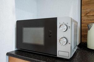 In the heart of a kitchen space, a microwave oven is prominently placed on the counter, ready for use to heat and cook various foods quickly and conveniently when needed photo