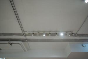 The ceiling showcases an impressive array of elegant, stylish lights suspended gracefully, creating a captivating and warm atmosphere throughout the entire space, inviting all who enter photo