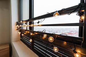 A beautifully designed window adorned with twinkling lights casts a cozy warm glow, beautifully illuminating the entire room and creating an ideal backdrop for relaxation and enjoyment photo