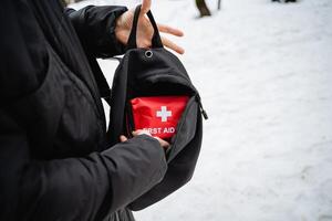 A person is holding a small, portable first aid kit carefully in their hand, ensuring it is ready to provide immediate assistance if needed in case of an emergency or injury photo