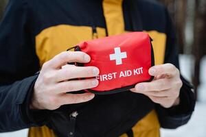 A person is cautiously holding onto a first aid kit, making sure that it is easily accessible for any potential emergencies that may arise, prepared for immediate use if required photo