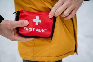 A person is currently and carefully holding a first aid kit in their pocket for easy access and convenience during emergencies or when immediate first aid assistance is required urgently photo