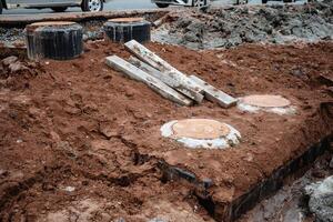 A sizable pile of dirt, mixed with several pieces of wood and other materials, can be seen at the construction site, indicating ongoing geological activity related to the project photo
