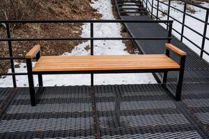 A robust and sturdy wooden bench is carefully placed on a durable metal platform adjacent to the stairs, enhancing the inviting and functional experience of the outdoor seating area photo