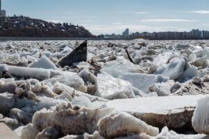 A large and impressive pile of ice is sitting peacefully on the shore of a serene lake, creating a stunning winter landscape. Its presence evokes a sense of cold beauty and tranquility photo