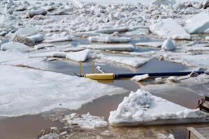 In a picturesque scene, a bright yellow boat is gently floating atop a puddle of ice, highlighting the striking contrast of color against the cold, icy landscape around it photo