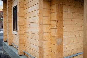 This image showcases a detailed closeup view of a wooden house that is currently under construction, emphasizing an unfinished window and the continuous effort being put into the project photo