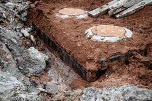 There exists an accumulative mass of earth, known as dirt, with a solid concrete block situated right in the middle of it, creating an interesting juxtaposition of materials and textures photo