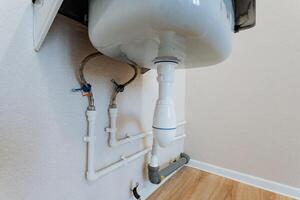 A functional bathroom sink that is equipped with a drain pipe connected to it for proper water disposal and plumbing efficiency, ensuring hygiene and cleanliness in the bathroom space photo