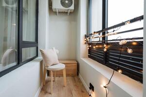 On the balcony, which enhances the charm of the apartment, there sits a cozy chair alongside a cooling fan, creating a perfect space for relaxation and enjoyment of the outdoors photo