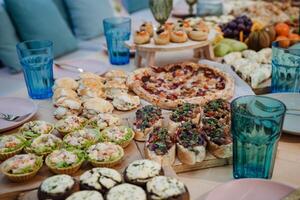 A beautifully arranged table is adorned with a diverse collection of delicious food items and an assortment of refreshing drinks, creating an inviting atmosphere for everyone present photo