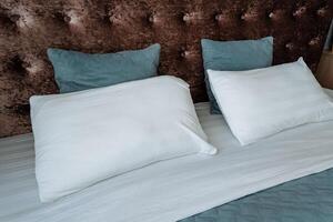 The comfortable bed is adorned with crisp white sheets and soft blue pillows, creating a serene and inviting atmosphere in the room, perfect for relaxation or a good nights sleep photo