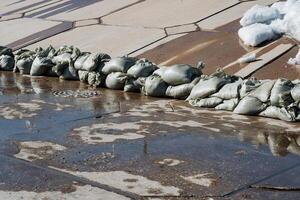 Implementing effective flood protection measures using sandbags on a wet surface can significantly mitigate damage during floods and is essential for infrastructure resilience photo
