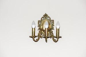 golden lamp on the background of a white wall photo
