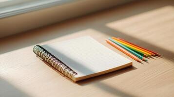 Creative writing setup with empty notebook and colorful pencils bright natural light background minimalist style photo