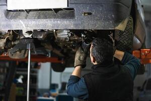 Anonymous repairman removing car details with torch during work in auto service photo