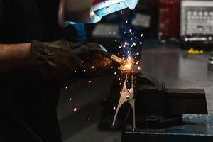 Anonymous mechanic welding metal construction in workshop photo