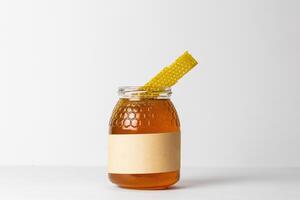 Honey with honeycomb in glass jar photo