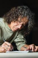 Male carpenter creating sketch in notebook in workshop photo