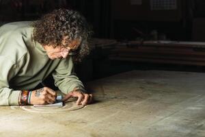 Male carpenter creating sketch in notebook in workshop photo