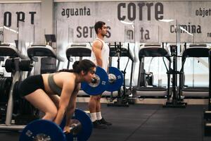 A man and woman in a gym doing squats photo